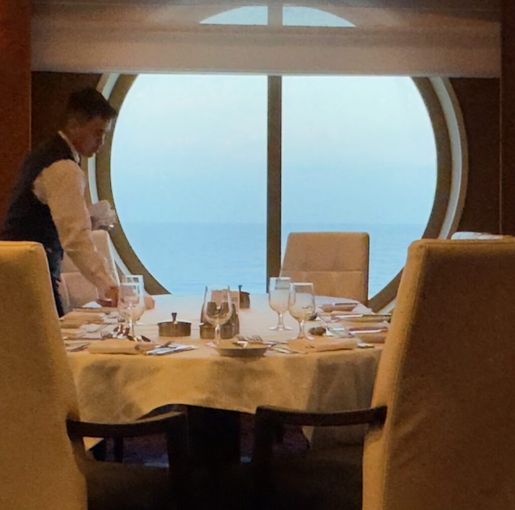 Crew about Royal Caribbean's Explorer of the Seas set a table in the Main Dining Room (MDR).